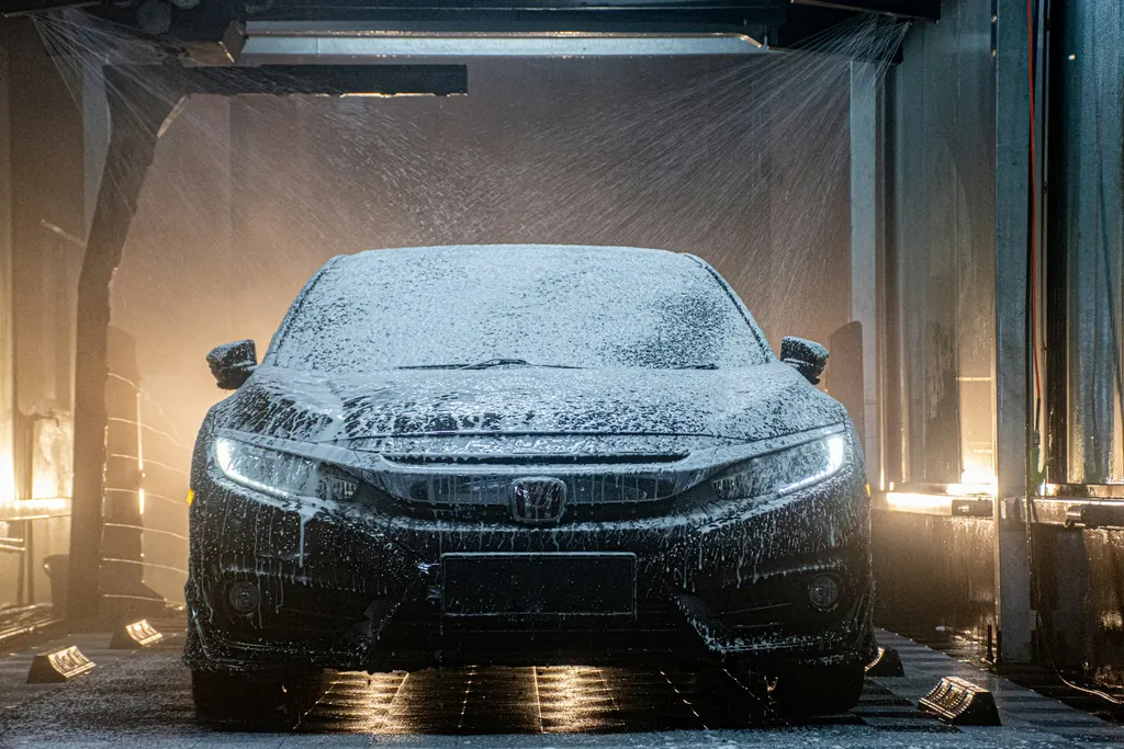 Controlled wash-process atmosphere for exterior detailing context, not a cheap hand car wash scene presented as this studio.
